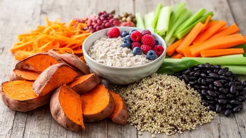Vibrant whole food carbohydrate sources including sweet potatoes, oats, berries, and legumes.